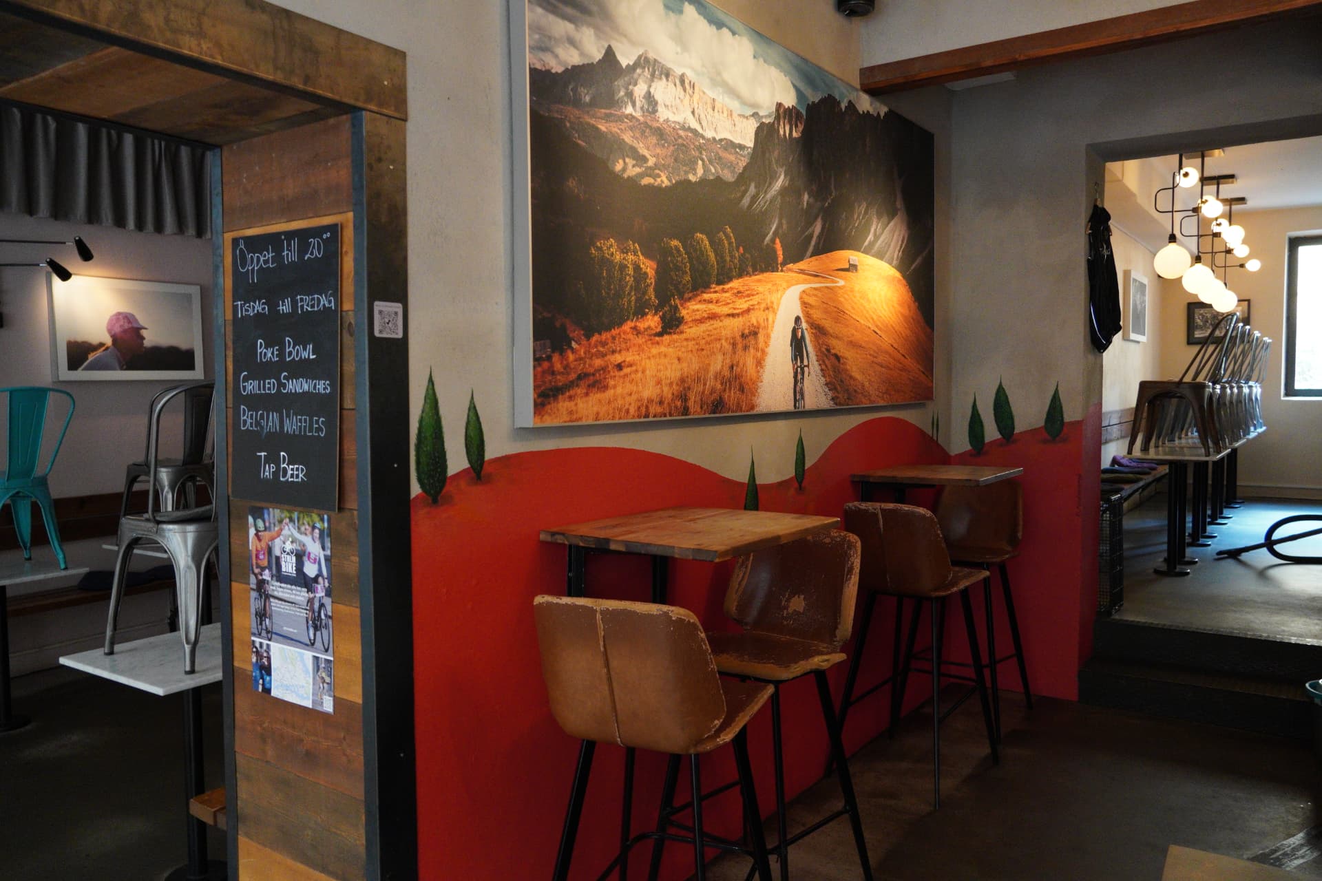 A hand-painted mountain landscape mural inside a cozy café